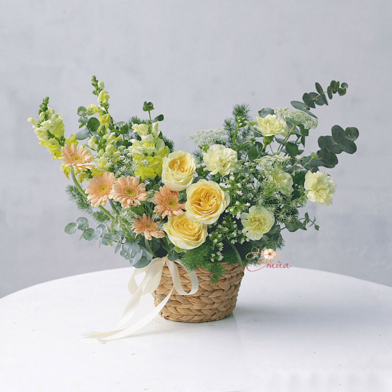 Một bình hoa tươi được cắm tỉ mỉ, kết hợp nhiều loại hoa và lá, thể hiện sự tinh tế và chuyên nghiệp, phù hợp với không gian sang trọng của người tuổi Dần.
