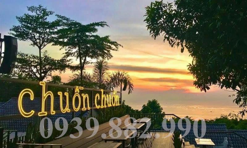 Một bó hoa tươi tắn, nhiều màu sắc được đặt cạnh nơi có chuồn chuồn bay lượn, nhấn mạnh mối liên hệ giữa hoa và thiên nhiên, biểu tượng cho sự sống động và niềm vui