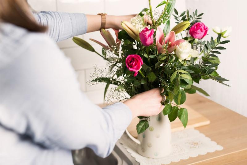 Một bình hoa tươi đẹp được đặt trên bàn, thể hiện cách bảo quản hoa đúng cách trong môi trường mát mẻ, tránh ánh nắng trực tiếp, giúp hoa giữ được độ tươi lâu hơn.
