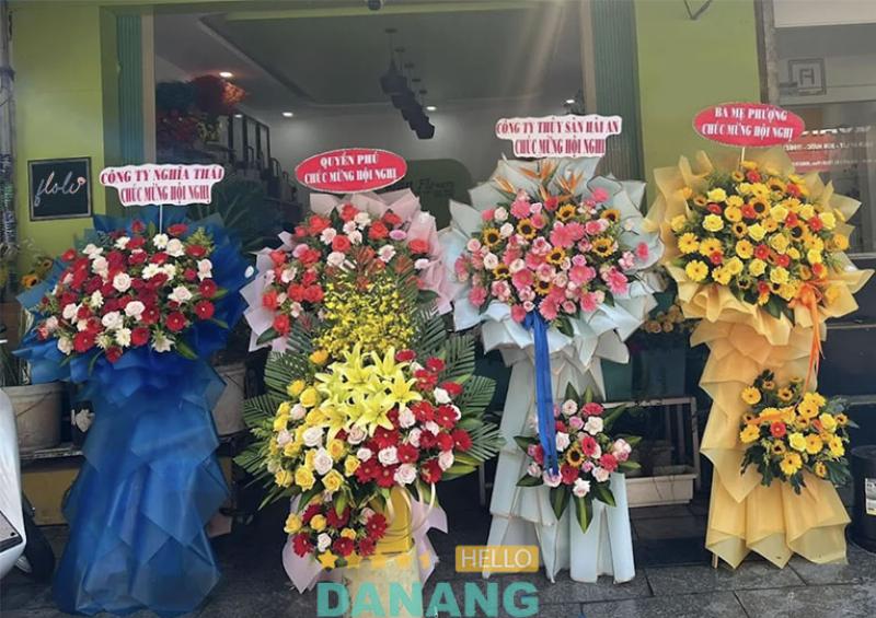 Hình ảnh nhân viên Hoa Tươi Thanh Thảo đang tư vấn cho khách hàng về cách chọn hoa tươi hợp mệnh, với các bó hoa rực rỡ và tươi mới trưng bày quanh đó.