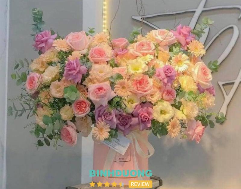Một nhân viên của Hoa Tươi Thanh Thảo đang tỉ mỉ sắp xếp những bông hoa tươi trong cửa hàng, thể hiện sự tận tâm và cam kết về chất lượng dịch vụ