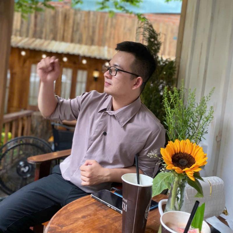 Hình ảnh một người đang ngồi ngắm nhìn những bông hoa trong vườn, với một chú chuồn chuồn đang bay gần đó, thể hiện sự kết nối và bình yên khi hòa mình vào thiên nhiên