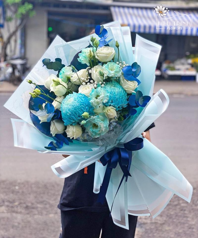 Một người phụ nữ tươi cười đang sắp xếp những bó hoa tươi rực rỡ trong cửa hàng Hoa Tươi Thanh Thảo, thể hiện sự chuyên nghiệp và đam mê