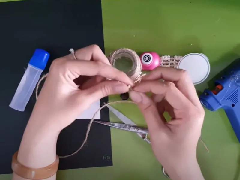 Cột cố định dây thừng lại và tạo hình chiếc nơ trang trí lọ hoa
