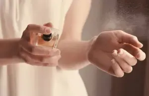 Cách sử dụng nước hoa hiệu quả: một người đang xịt nước hoa tự làm lên cổ tay để kiểm tra mùi hương và độ lưu giữ.