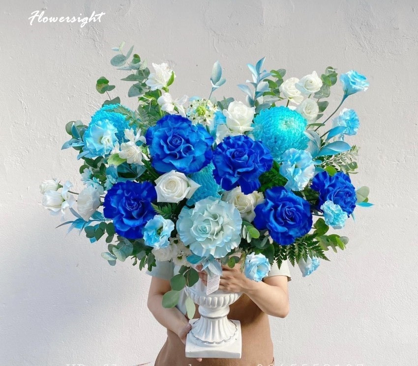 Lẵng hoa hồng nhiều màu sắc, với các loại hoa phụ và lá xanh, tạo vẻ đẹp sang trọng và trang nhã