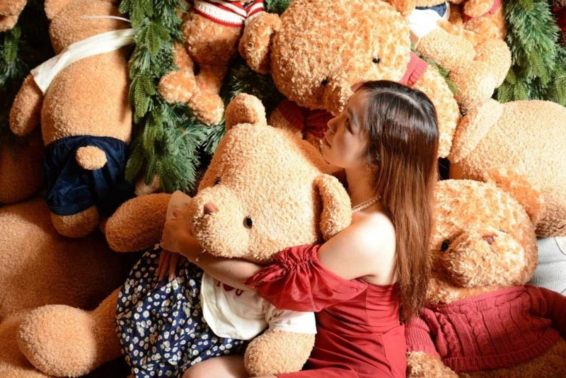 Chú gấu bông màu nâu khổng lồ ngồi trên ghế sofa