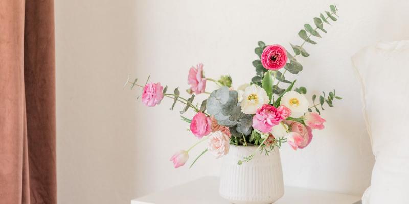 Một người lớn tuổi đang bỏ đường vào bình nước cắm hoa, minh họa mẹo dân gian bỏ đường vào nước cắm hoa