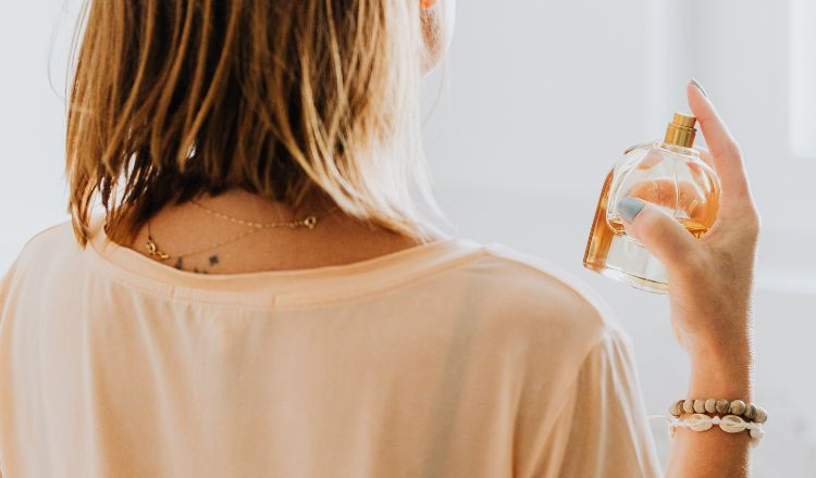 Người đang xịt nước hoa trực tiếp lên chiếc áo sơ mi màu trắng