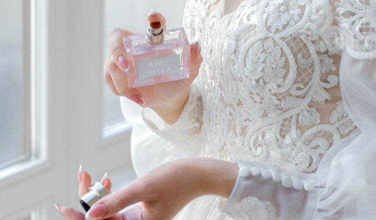 Người phụ nữ đang xịt nước hoa vào vùng cổ tay của mình